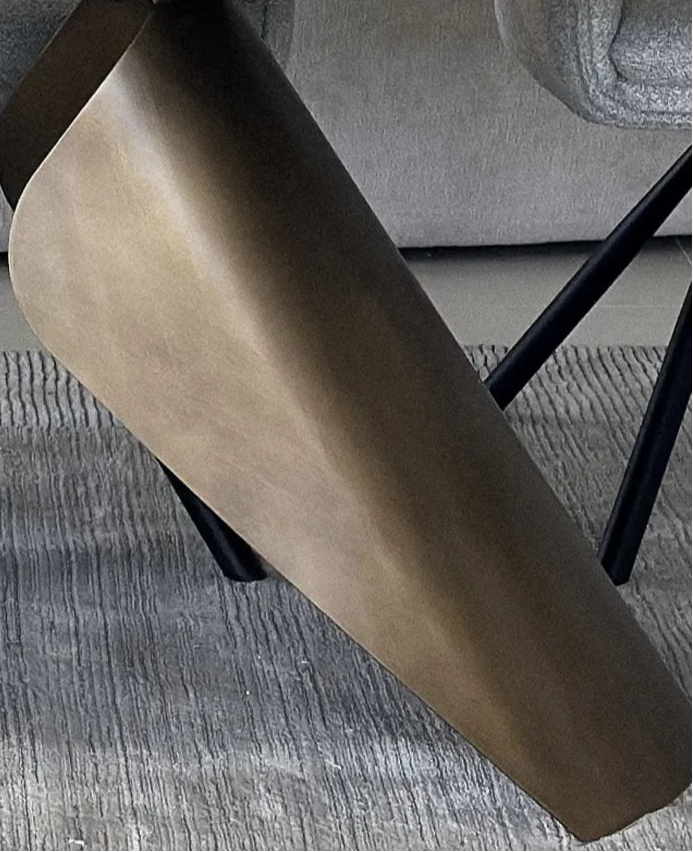Close-up of a table with metallic legs on a carpeted floor.