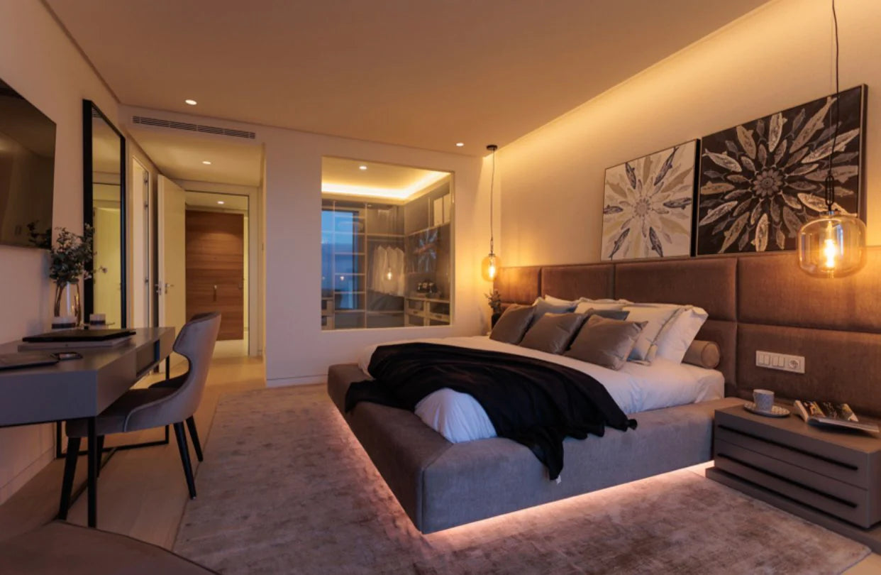 Modern bedroom with a large bed, desk, and wall art.